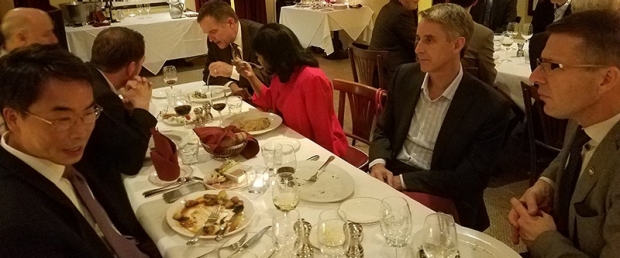 seven people at a restaurant having dinner and discussion
